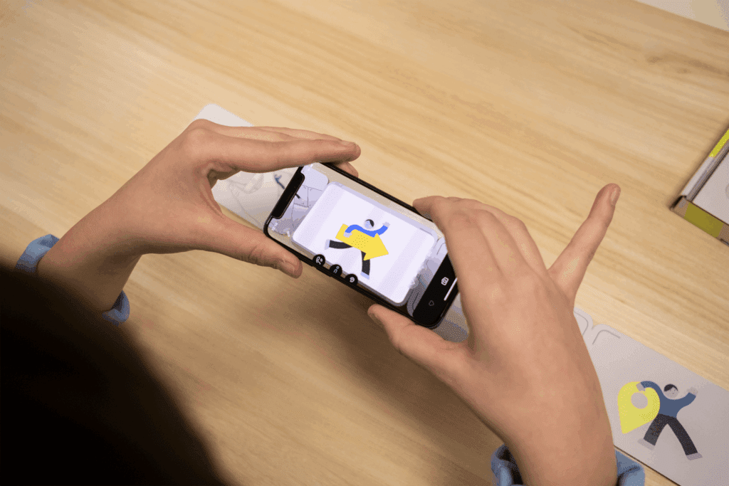 Ein Mensch scannt ein Bild auf dem Leporello mit Hilfe der App ein.