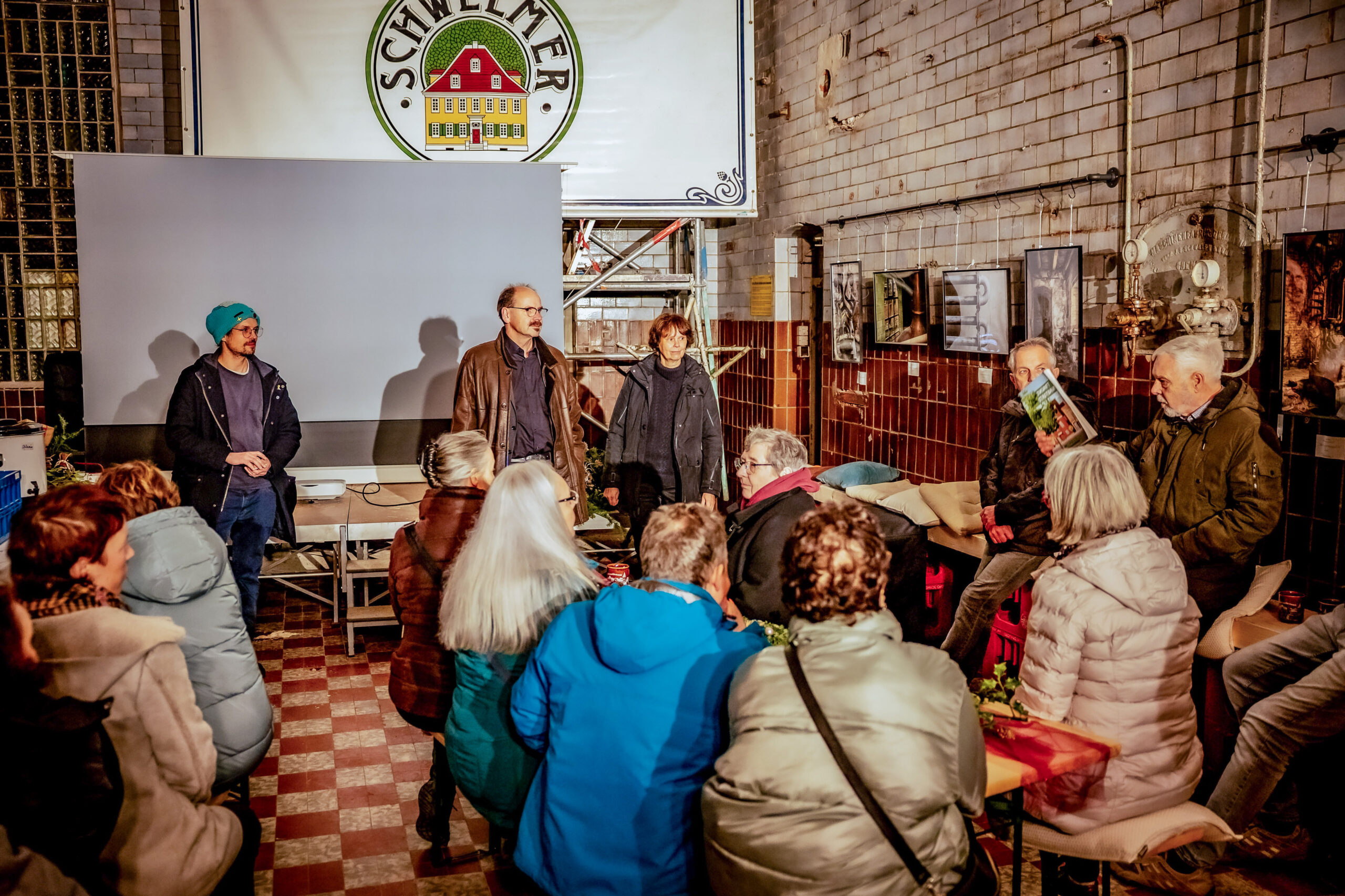 A group of visitors at a gathering in the historic rooms of the Schwelm Brewery.