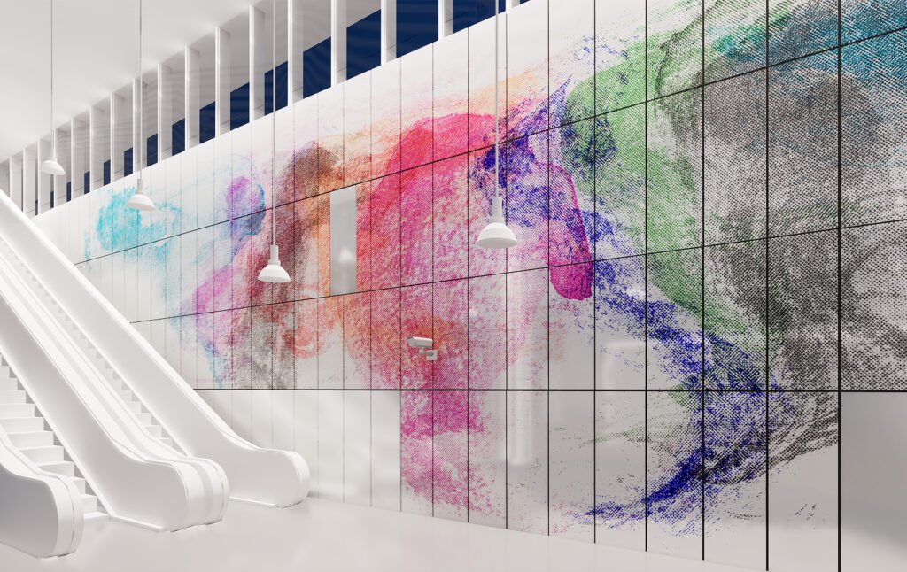 A large-scale wall installation in a bright subway station featuring colorful, pixel-like structures made of enameled panels. The abstract forms extend across several wall sections next to escalators and combine motifs of mobility and nature in the art project *Swift Messengers*. 